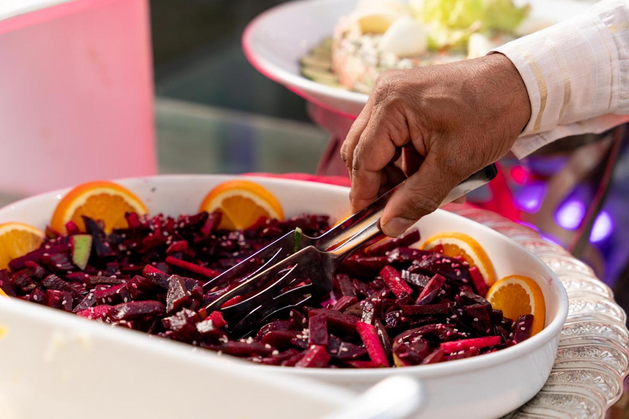 Sheraton Dammam Hotel & Convention Centre Exterior foto A hand using a buffet server to serve food